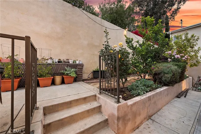 a view of a patio with couches and table and chairs and potted plants
