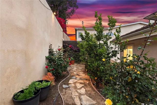 a view of a pathway with a flower garden
