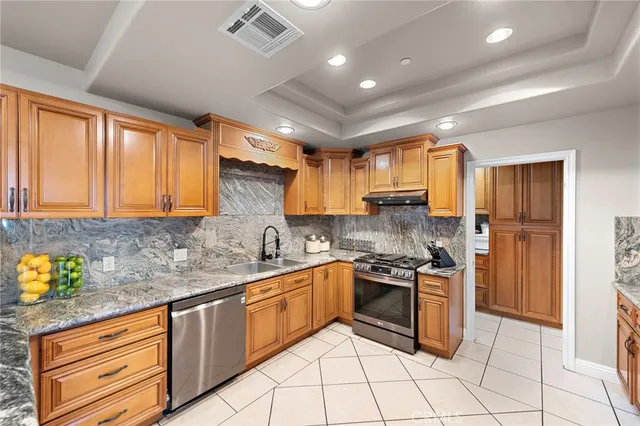 a kitchen with stainless steel appliances granite countertop a sink stove and cabinets
