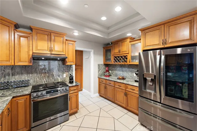 a kitchen with stainless steel appliances granite countertop a stove a sink and a refrigerator