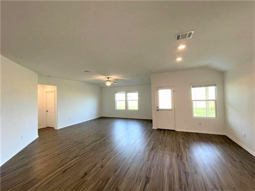 409 Bluejack Way Hutto, TX 78634 - Photo 12 of 28 an empty room with wooden floor and windows