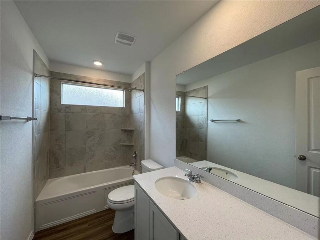 409 Bluejack Way Hutto, TX 78634 - Photo 14 of 28 a bathroom with a sink a toilet and shower