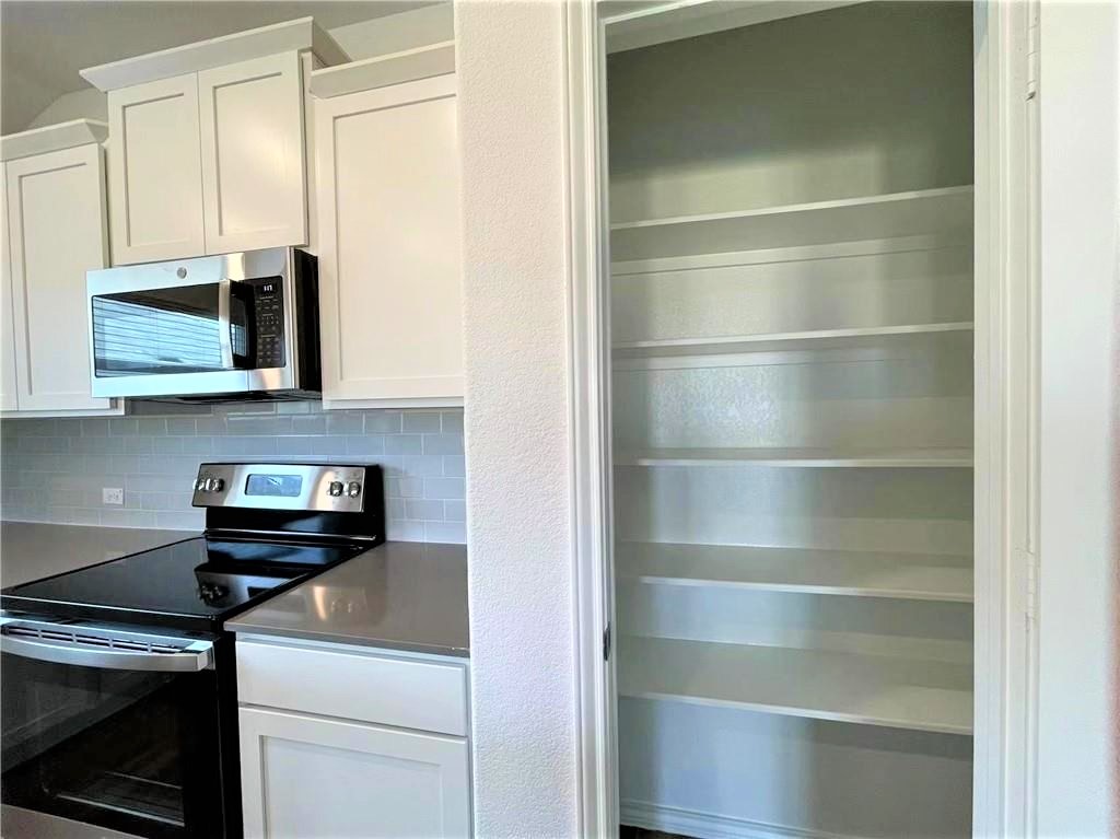 409 Bluejack Way Hutto, TX 78634 - Photo 3 of 28 a kitchen with a stove and a microwave