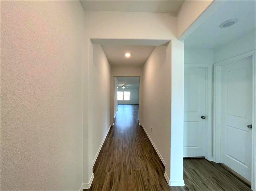 409 Bluejack Way Hutto, TX 78634 - Photo 5 of 28 a view of a hallway with wooden floor