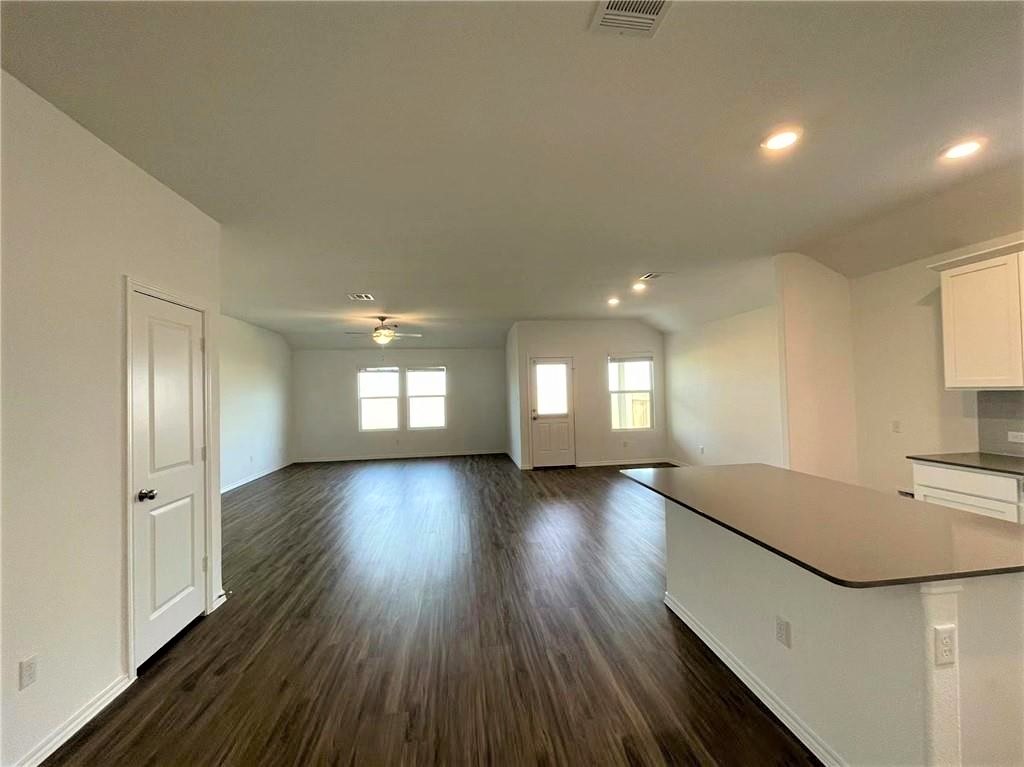 409 Bluejack Way Hutto, TX 78634 - Photo 9 of 28 a view of an empty room with wooden floor and a window