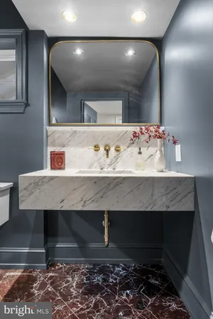 a bathroom with a toilet sink and mirror