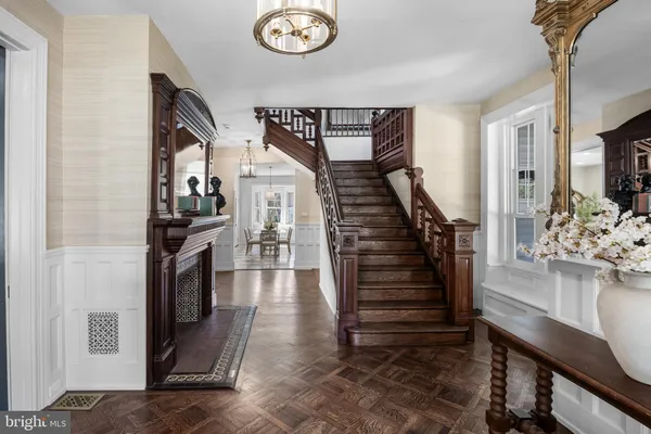 a living room with furniture a fireplace and a chandelier
