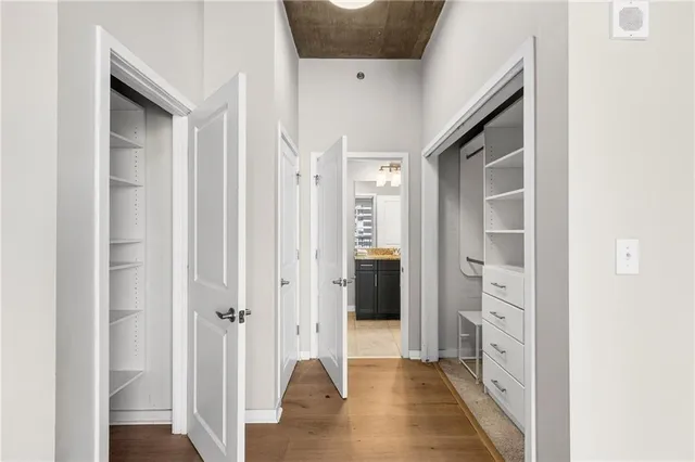 a view of a hallway with closet and wooden floor
