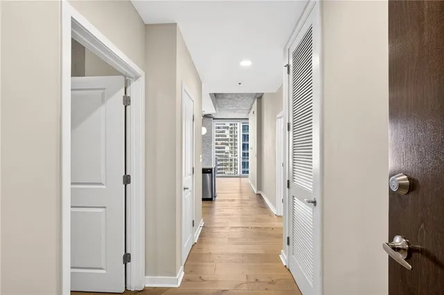 a view of a hallway with wooden floor and closet area