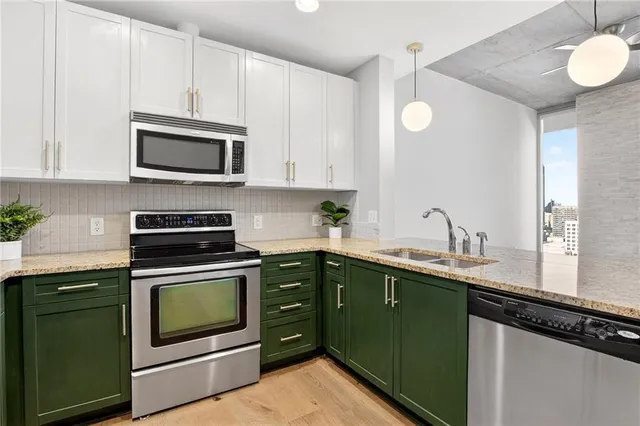 a kitchen with cabinets stainless steel appliances a sink and a microwave