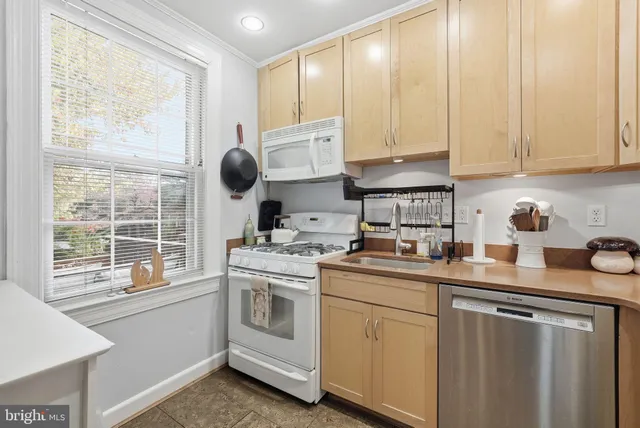 a kitchen with white cabinets and white appliances