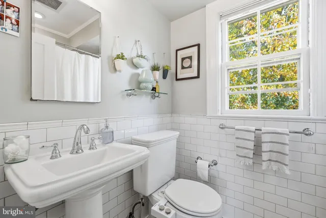a bathroom with a sink a toilet and a mirror
