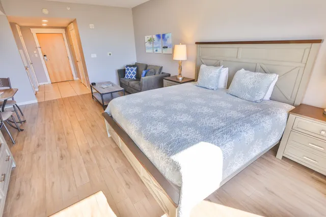 a bed sitting in a bedroom and wooden floor