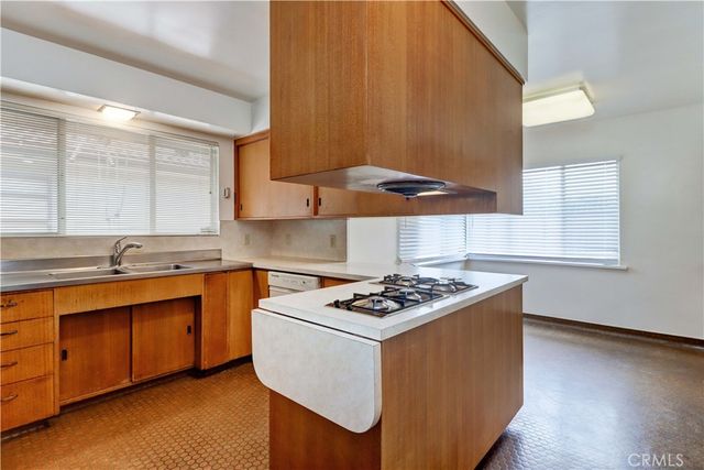 a kitchen with stainless steel appliances a sink a stove and white cabinets