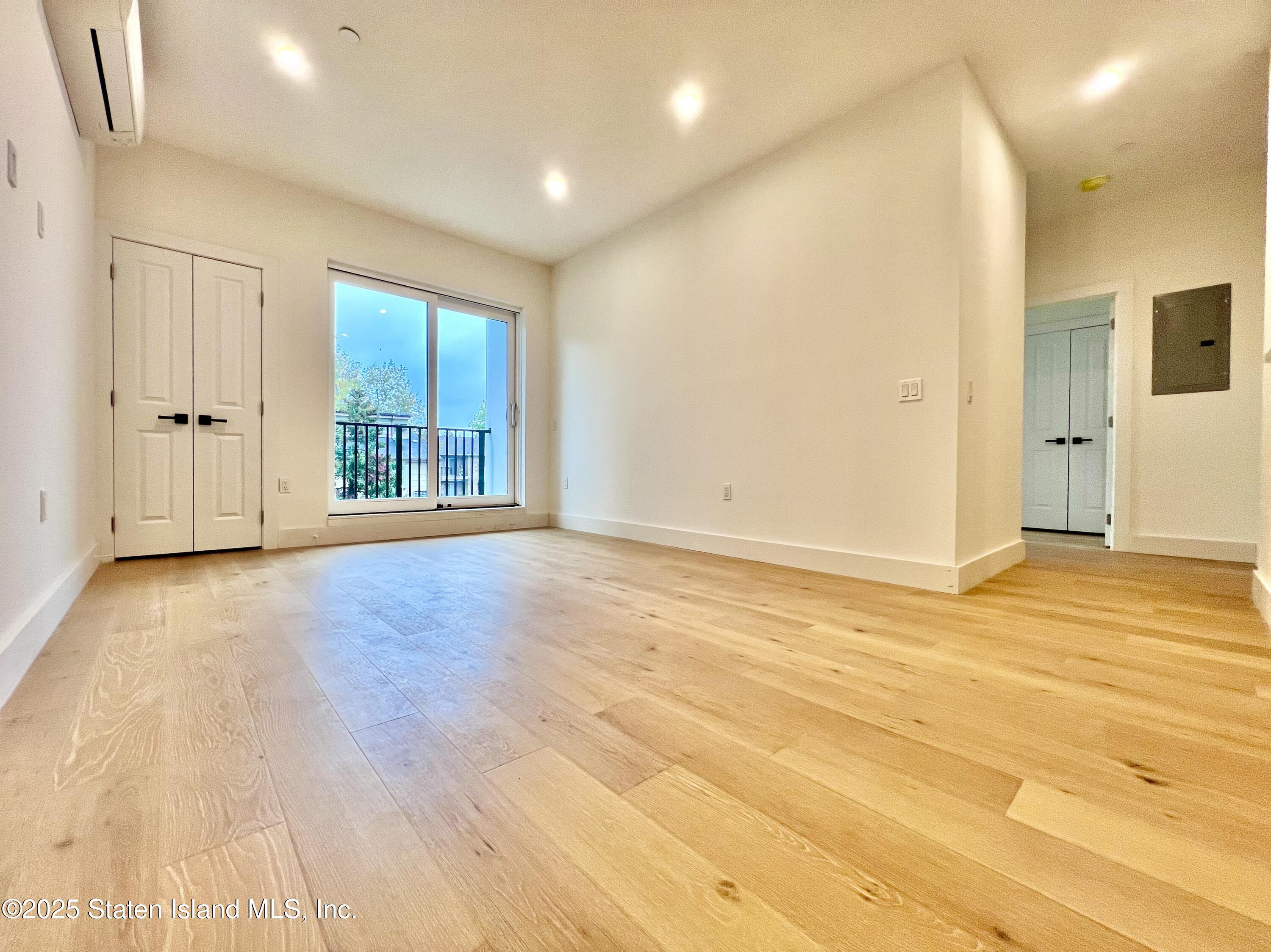 3865 Amboy Road, Unit 3D Staten Island, NY 10308 - Photo 16 of 36 a view of an empty room with wooden floor and windows