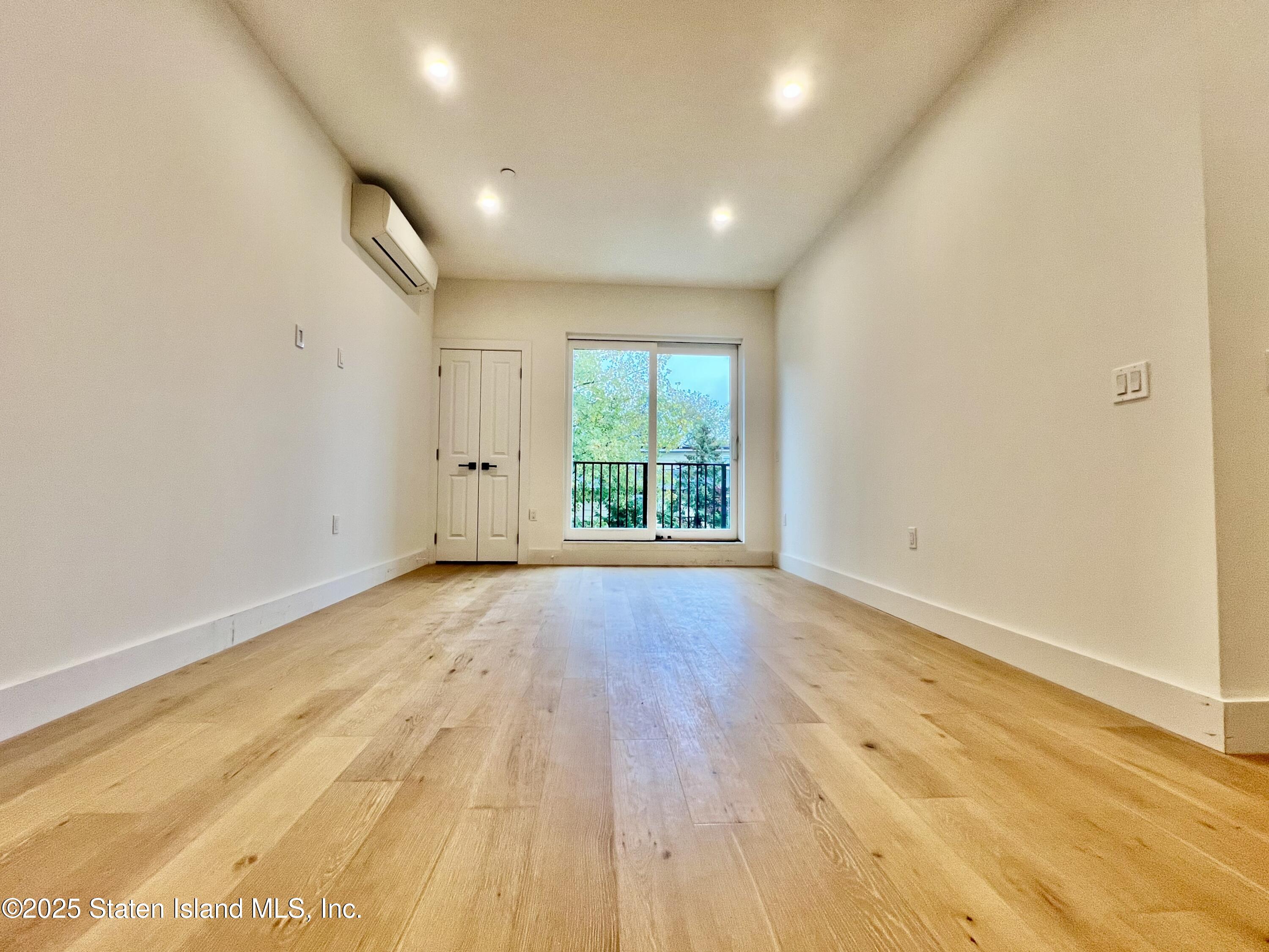 3865 Amboy Road, Unit 3D Staten Island, NY 10308 - Photo 17 of 36 an empty room with wooden floor and windows