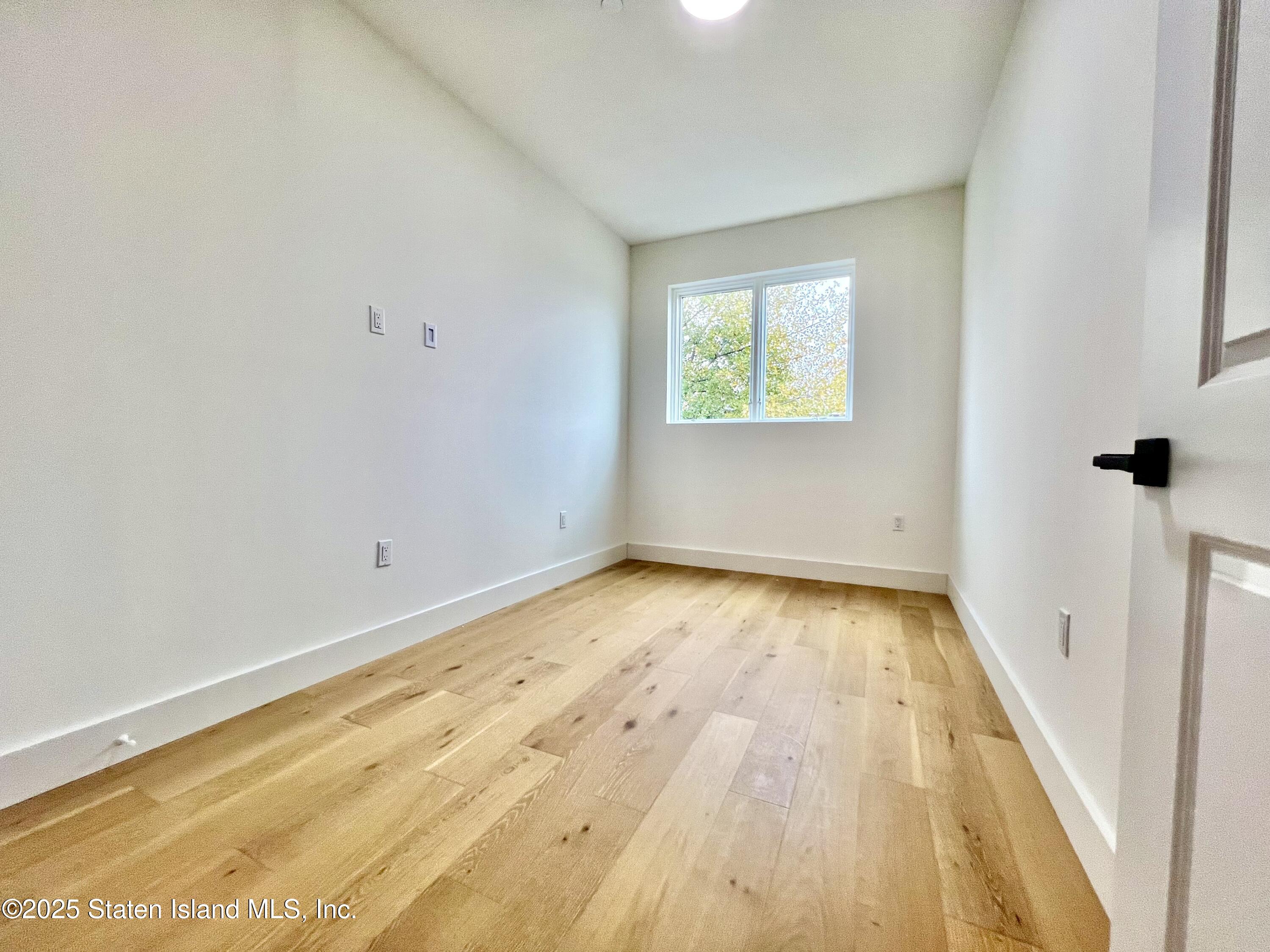 3865 Amboy Road, Unit 3D Staten Island, NY 10308 - Photo 29 of 36 an empty room with wooden floor and windows