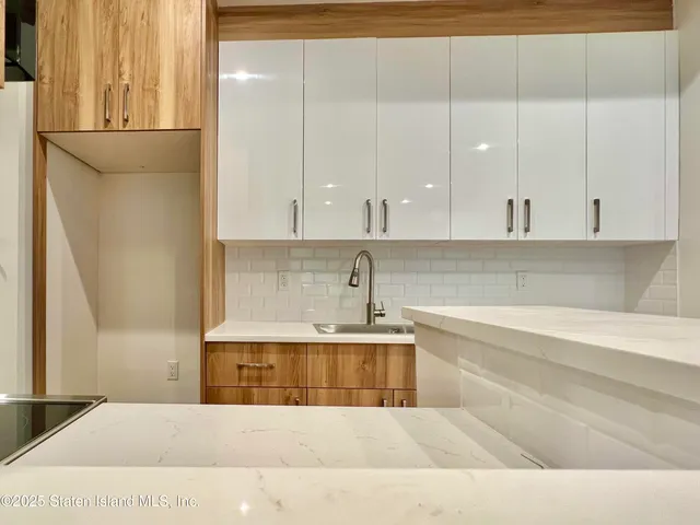 a large white kitchen with kitchen island granite countertop white cabinets and a sink