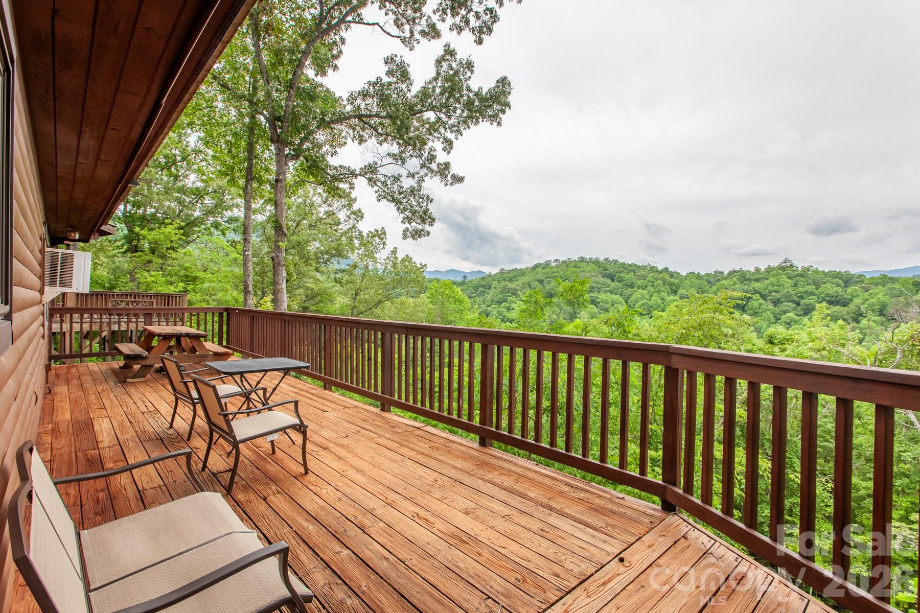 a balcony with wooden floor table and chairs
