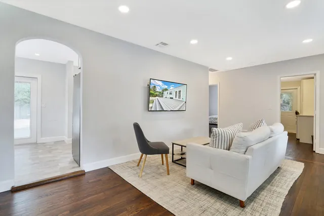 a living room with furniture and wooden floor