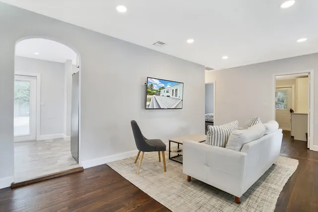 a living room with furniture and wooden floor