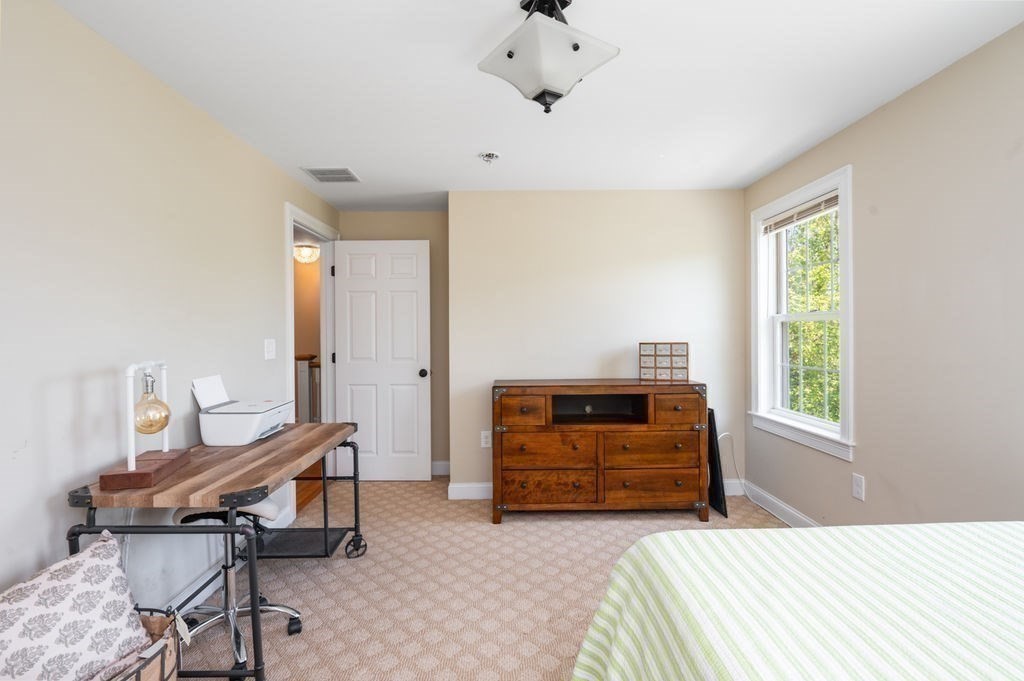1 Timber Lane, Unit B Amesbury, MA 01913 - Photo 22 of 41 a bedroom with a bed and a chandelier