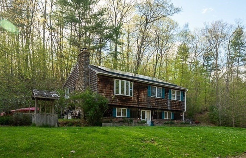 a view of house with yard and seating area