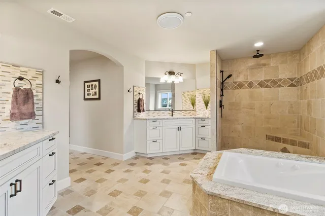 a bathroom with a bathtub sink and a mirror