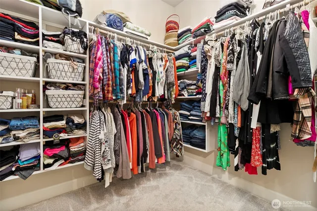 a view of walk in closet with clothes and shoes