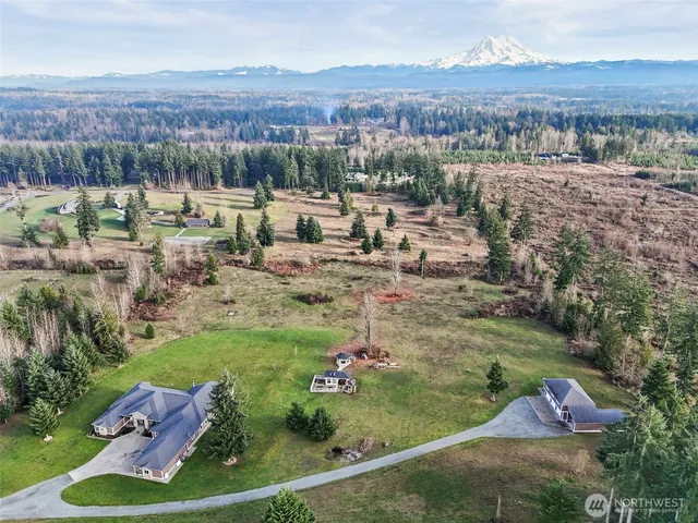 an aerial view of a house with a yard and lake view