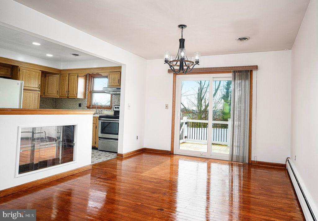 8007 Sagramore Road Baltimore, MD 21237 - Photo 12 of 41 a view of a kitchen with a stove wooden floor a kitchen view and a window