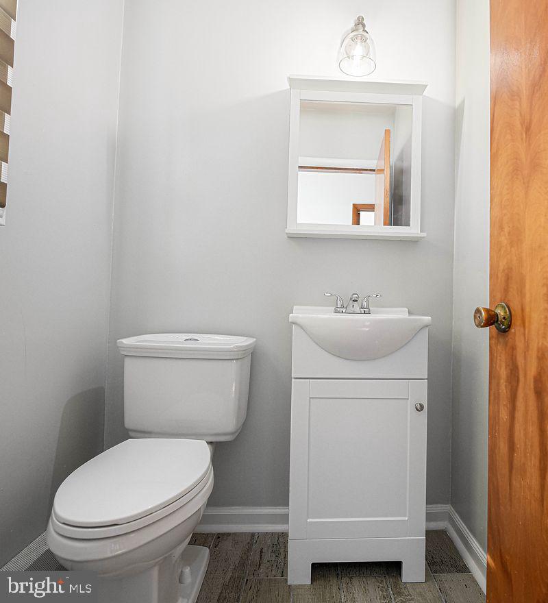 8007 Sagramore Road Baltimore, MD 21237 - Photo 16 of 41 a white toilet sitting next to a bathroom sink