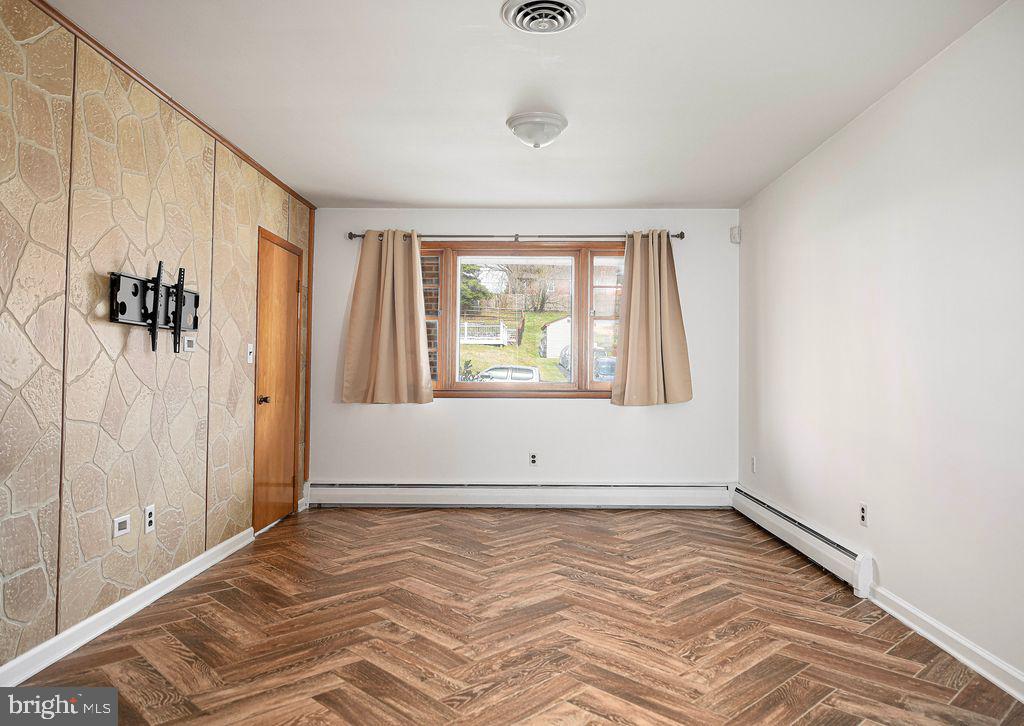 8007 Sagramore Road Baltimore, MD 21237 - Photo 17 of 41 an empty room with wooden floor and windows