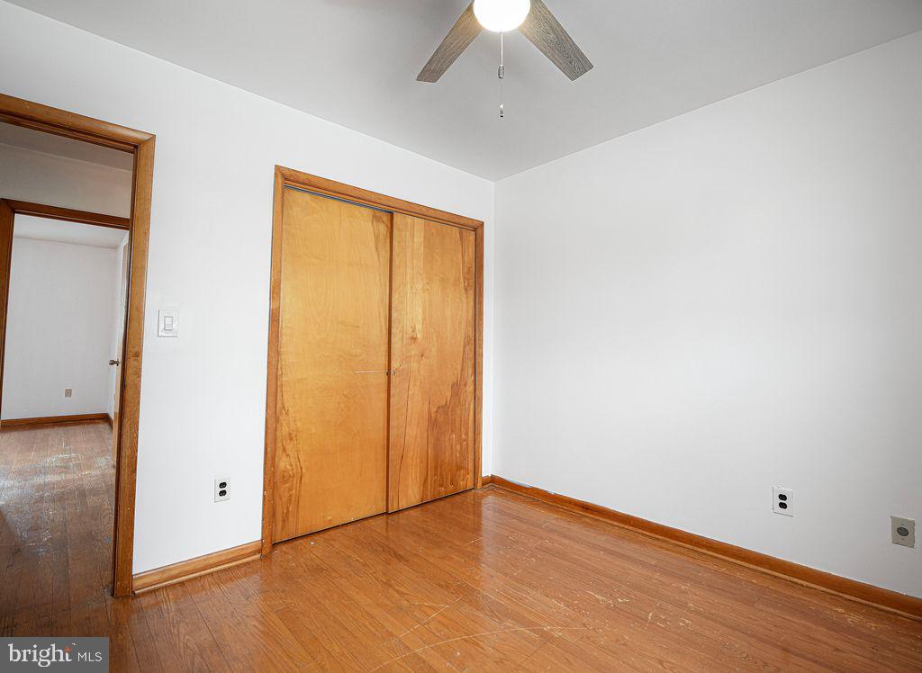 8007 Sagramore Road Baltimore, MD 21237 - Photo 23 of 41 an empty room with wooden floor and a ceiling fan