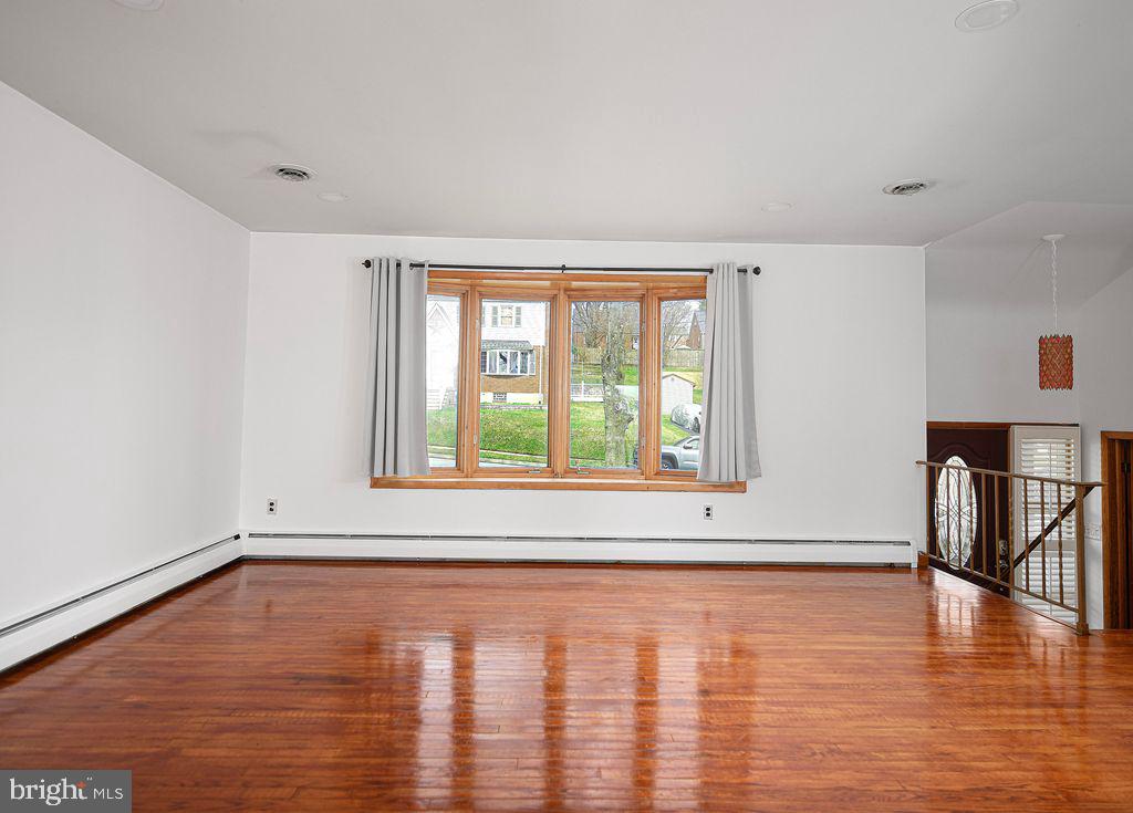 8007 Sagramore Road Baltimore, MD 21237 - Photo 5 of 41 a view of an empty room with window and wooden floor