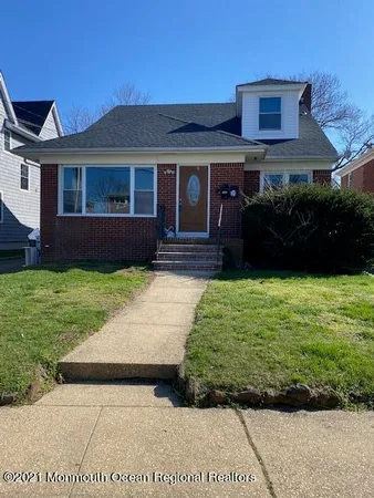 a front view of a house with a garden and yard