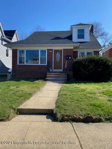 a front view of a house with a garden and yard