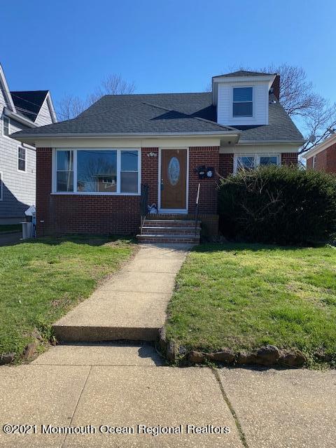 a front view of a house with a garden and yard