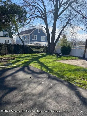 a front view of a house with a yard and trees