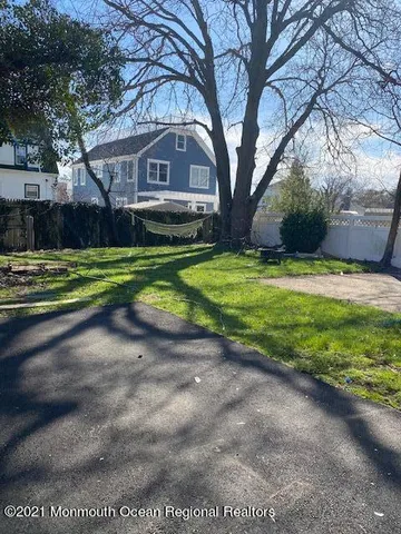 a front view of a house with a yard and trees
