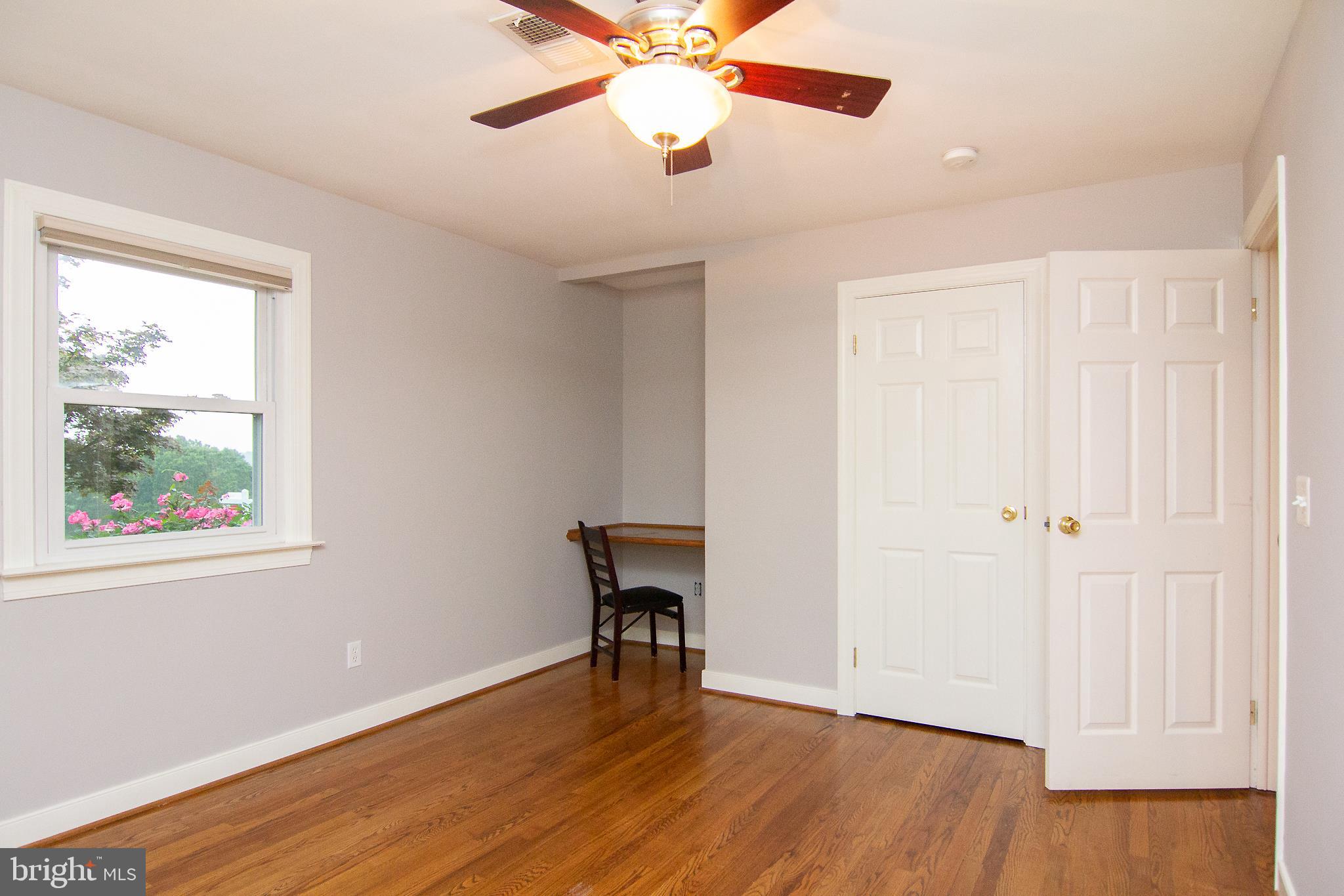 563 Oak Tree Road Westminster, MD 21157 - Photo 26 of 41 an empty room with wooden floor chandelier fan and windows