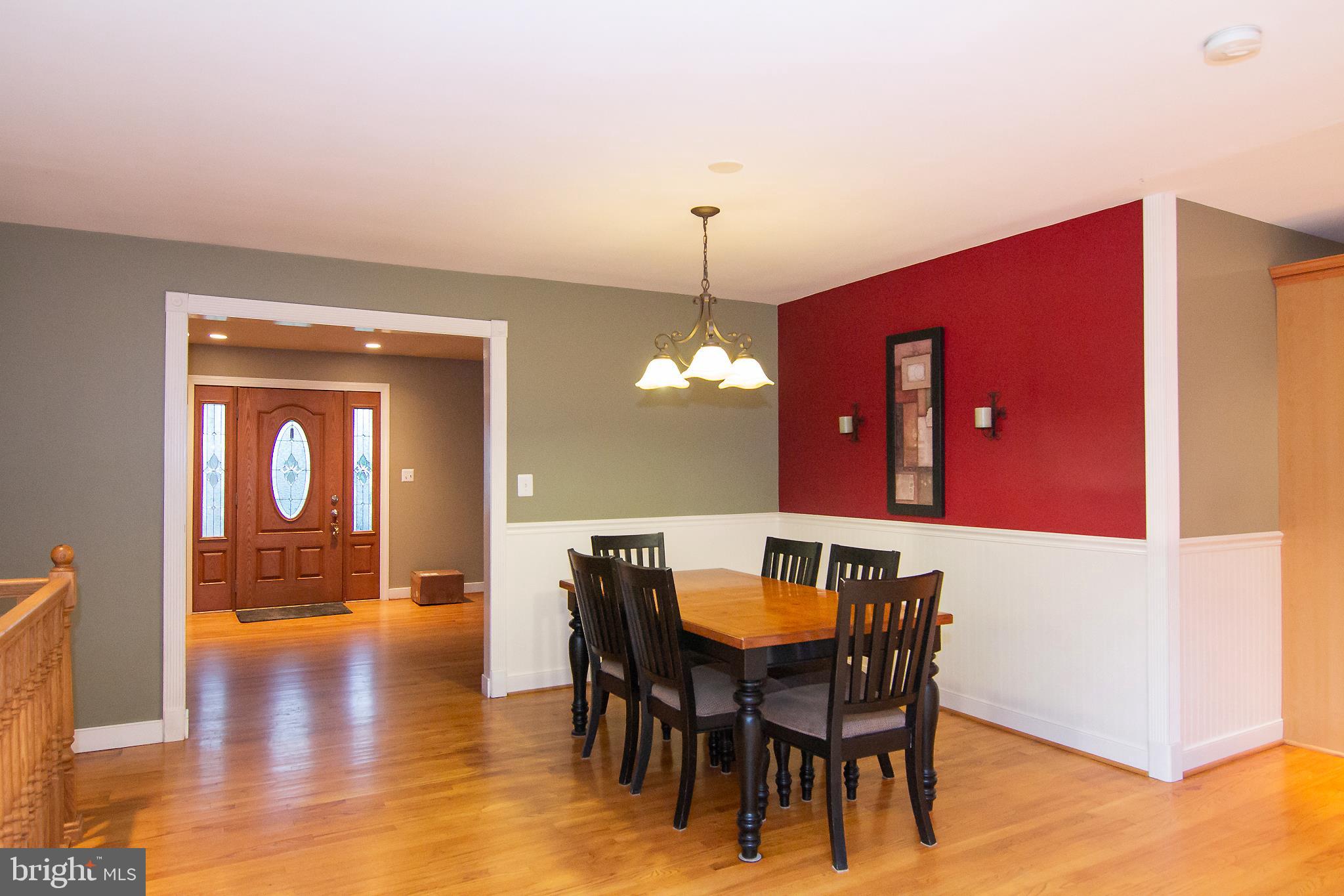 563 Oak Tree Road Westminster, MD 21157 - Photo 10 of 41 a dining room with furniture wooden floor a rug and a chandelier