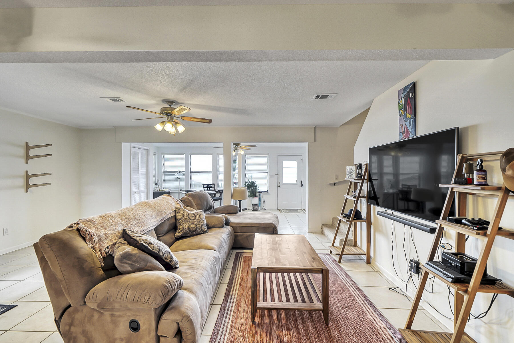 126 Walton Way, Unit 10 Miramar Beach, FL 32550 - Photo 6 of 28 a living room with furniture a ceiling fan and a flat screen tv