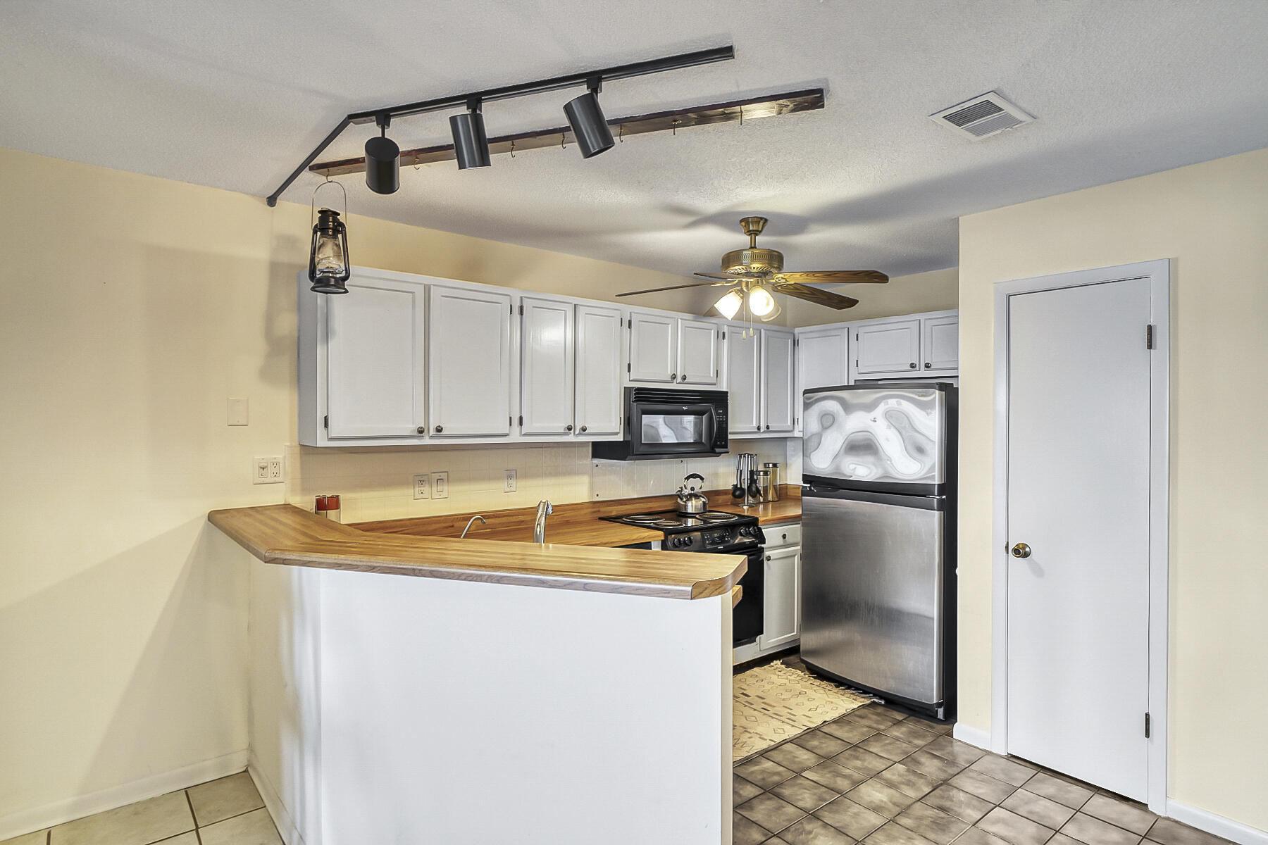 126 Walton Way, Unit 10 Miramar Beach, FL 32550 - Photo 8 of 28 a kitchen with stainless steel appliances granite countertop a refrigerator a sink and white cabinets