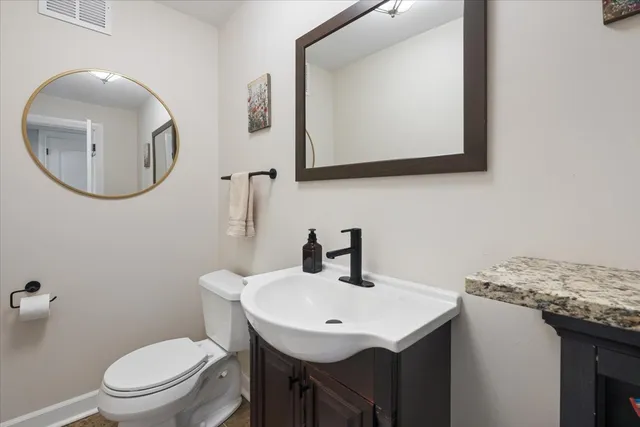 a bathroom with a toilet a sink and a mirror