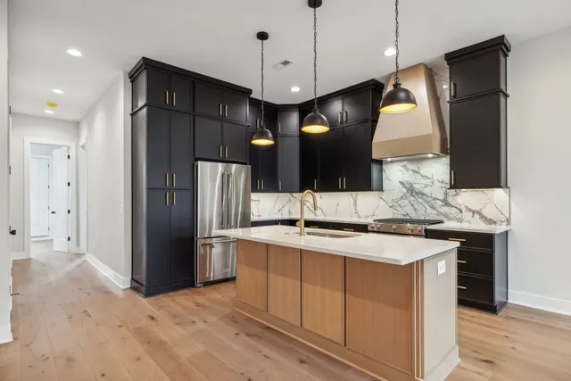 a kitchen with a sink a center island a stove and a refrigerator