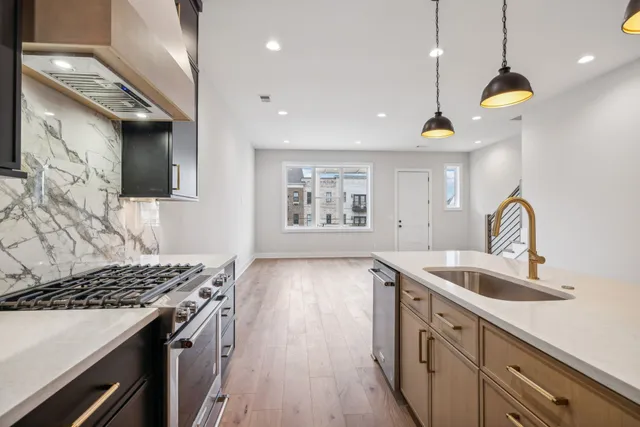 a kitchen with stainless steel appliances granite countertop a sink and a refrigerator