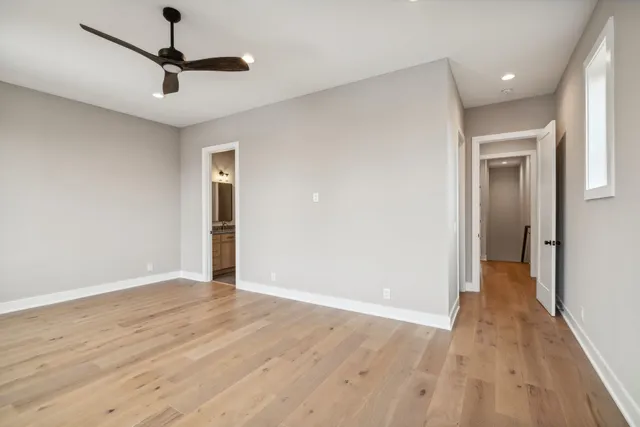 a view of an empty room with window and wooden floor