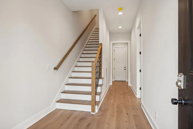 a view of a hallway with wooden floor and entryway