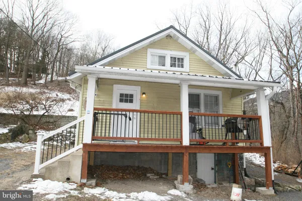 a view of a house with a yard and wooden fence